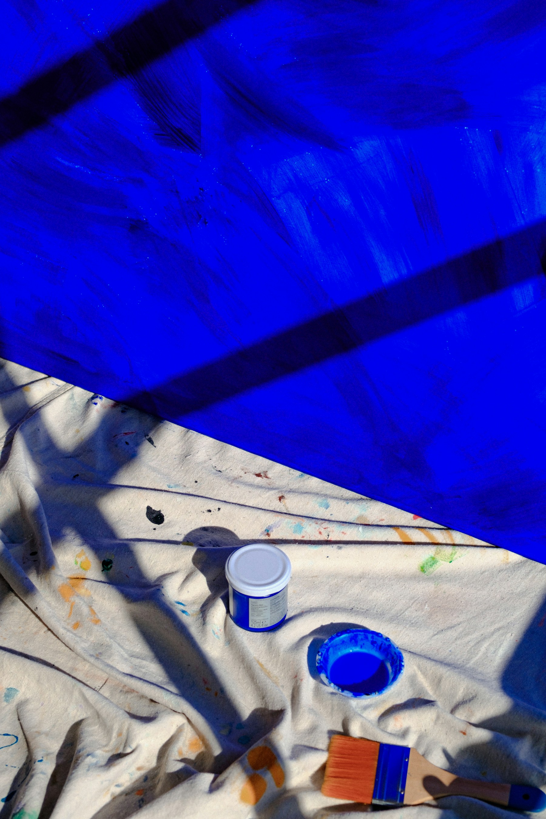 Paint cloth, brush, and blue painted surface used as painting context